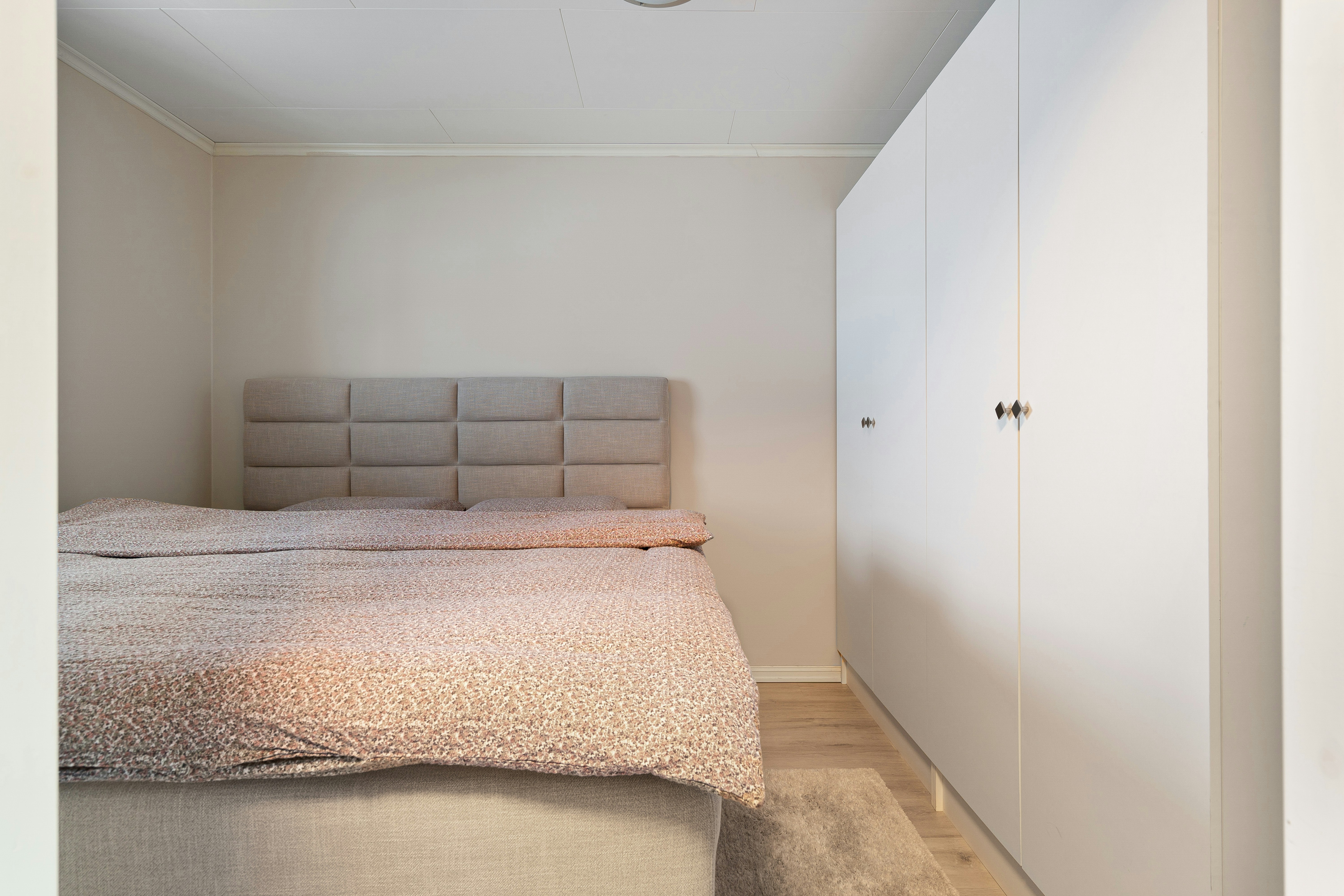A bed sitting in a bedroom next to a closet